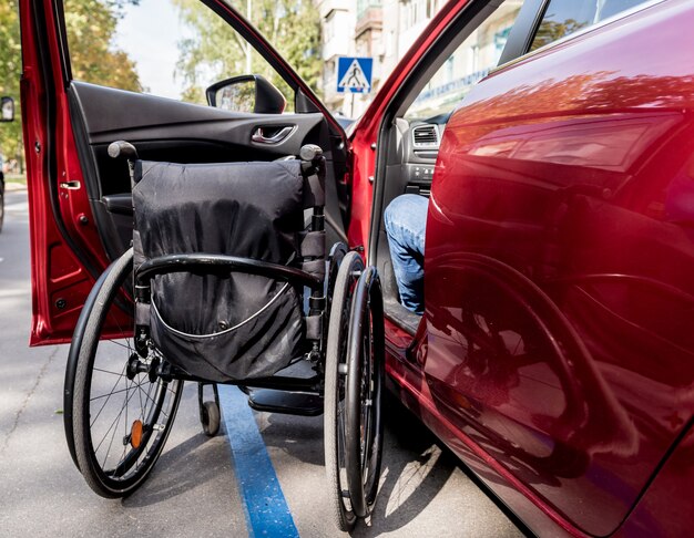 Giovane uomo disabile sul sedile del conducente della sua auto.