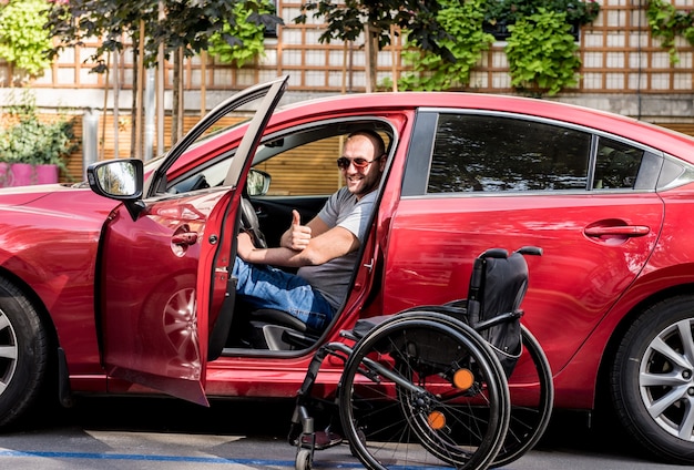 Young handicapped man on driver's seat of his car.