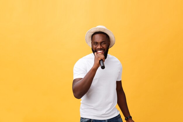 Young handsome african american boy singing emotional with microphone isolated