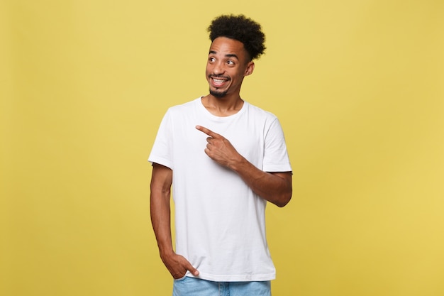 Young handsome african american man over yellow background pointing upwards.