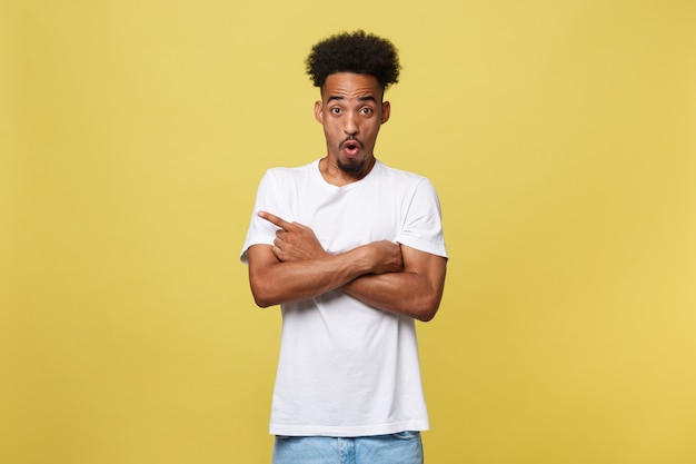 Young handsome african american man over yellow background pointing upwards.