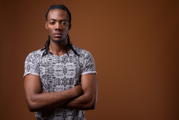 Young handsome African man against brown background