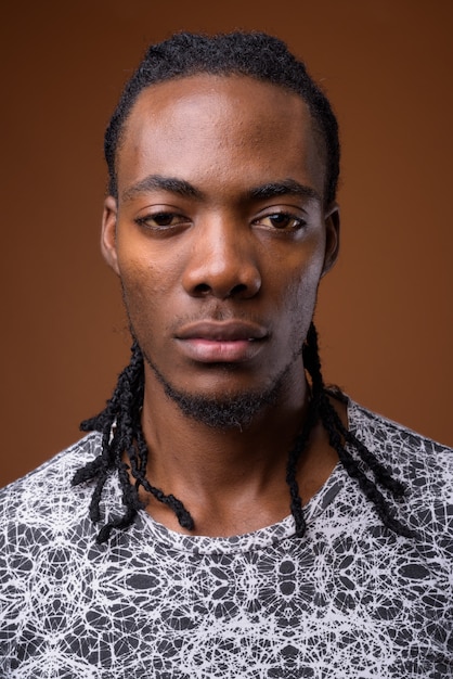 young handsome african man against brown background