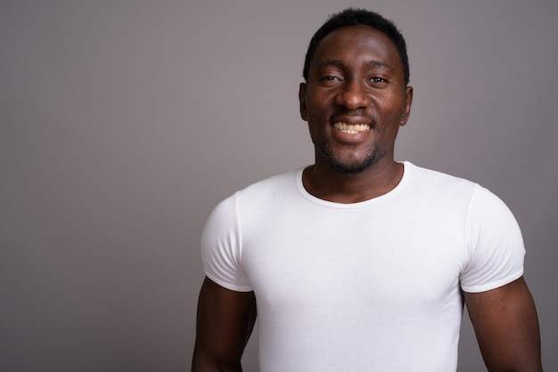 Young handsome African man against gray background