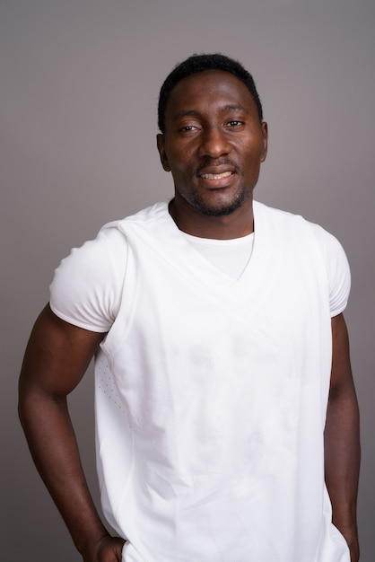 Young handsome African man against gray background