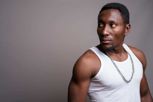 Young handsome African man against gray background