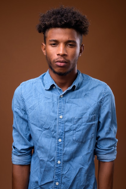 Photo young handsome african man on brown