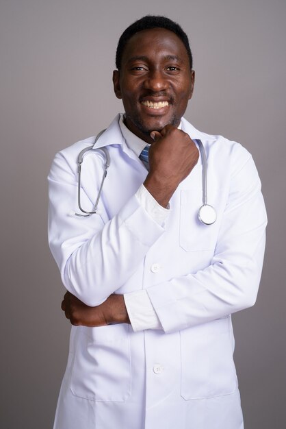 회색 배경에 젊은 잘 생긴 아프리카 남자 의사