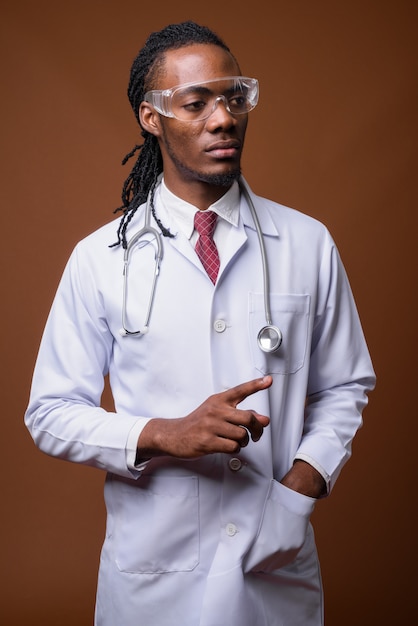 Young handsome African man doctor wearing protective glasses