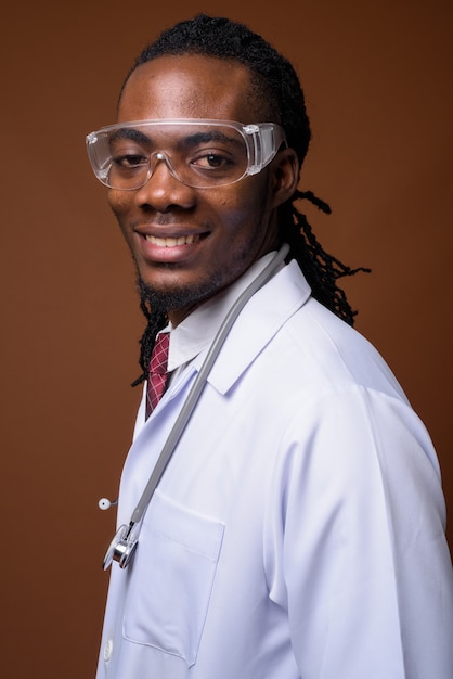 Young handsome African man doctor wearing protective glasses 