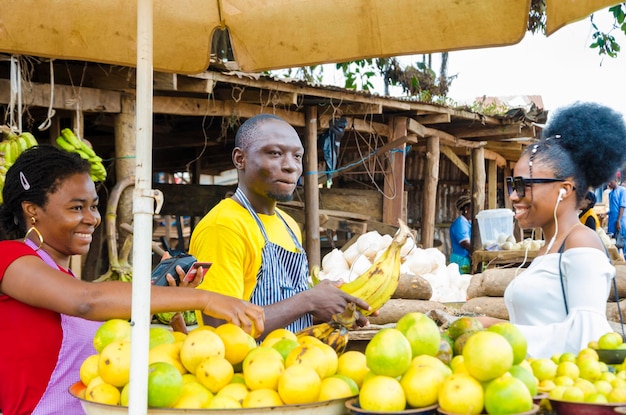 Un giovane africano bello che si sente eccitato mentre vende al suo bellissimo cliente mentre il suo collega tiene un punto vendita