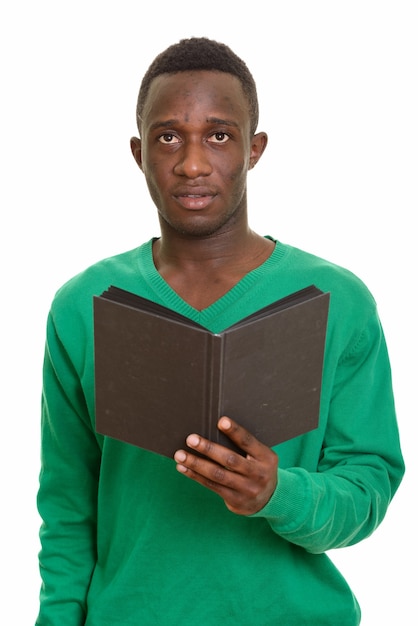 Giovane uomo africano bello che tiene libro mentre pensa