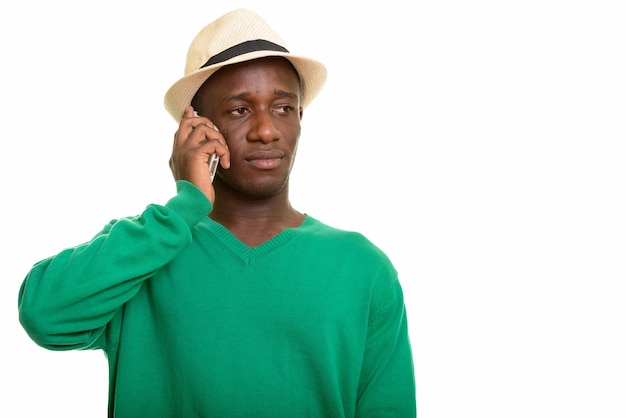 Young handsome African man talking on mobile phone while thinking