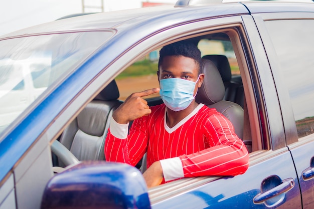 Young handsome african taxi driver wearing face mask preventing, prevent, prevented himself from the outbreak in the society