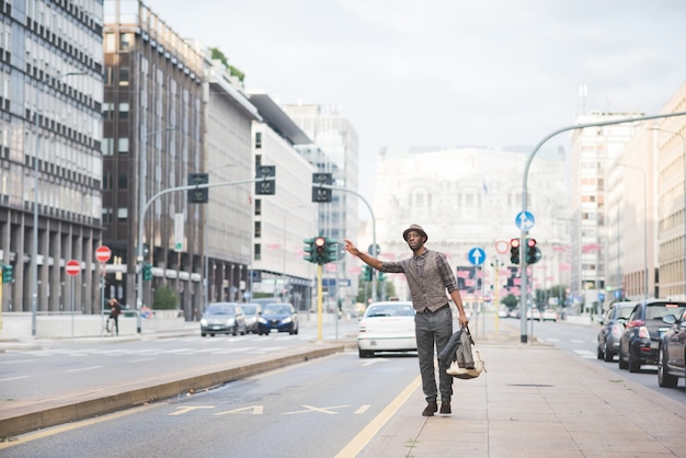 Young handsome afro black man walking in the street of the city