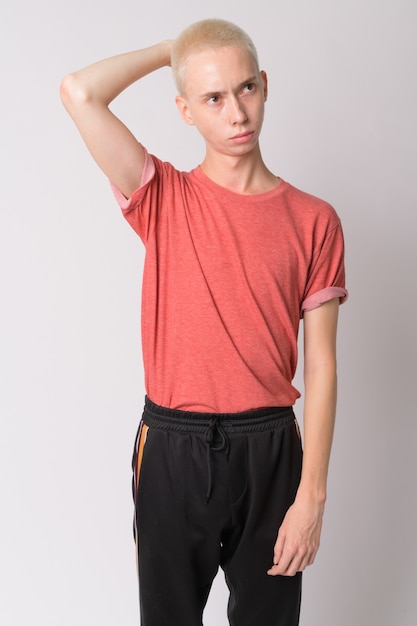 young handsome androgynous man against white wall