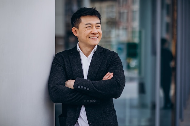 Young handsome asian business man in black suit