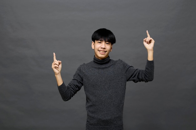 Young handsome Asian man posing at studio