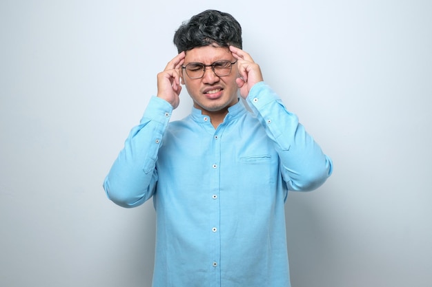 Young handsome asian man with hand on head for pain in head because stress Suffering migraine