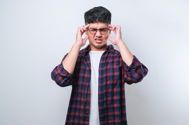Young handsome asian man with hand on head for pain in head because stress