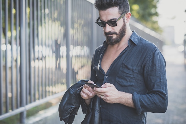 young handsome attractive bearded model man using smartphone