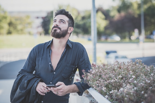 young handsome attractive bearded model man using smartphone