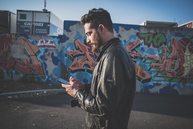 young handsome attractive bearded model man using smartphone