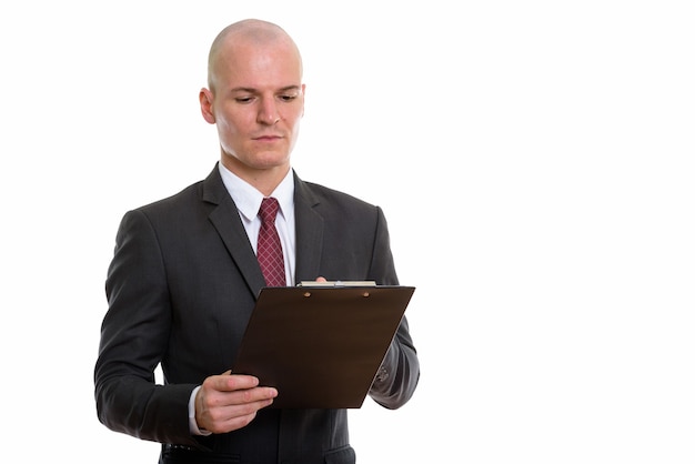 young handsome bald businessman reading on clipboard