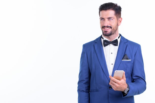  young handsome bearded businessman wearing suit isolated against white wall