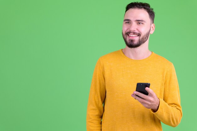  young handsome bearded man against chroma key with green wall