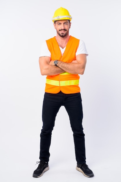  young handsome bearded man construction worker isolated against white wall
