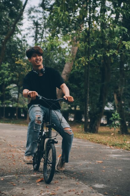 Young handsome bearded man taking a break while travelling the city with his bicycle using his digital tablet looking away thoughtfully