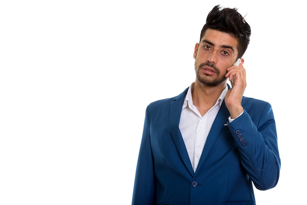 Молодой красивый бородатый персидский бизнесмен в костюме с помощью телефона