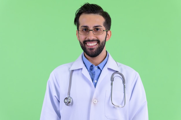 녹색 벽에 젊은 잘 생긴 수염 된 페르시아 남자 의사