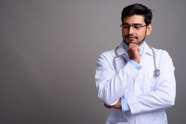 young handsome bearded Persian man doctor wearing eyeglasses 