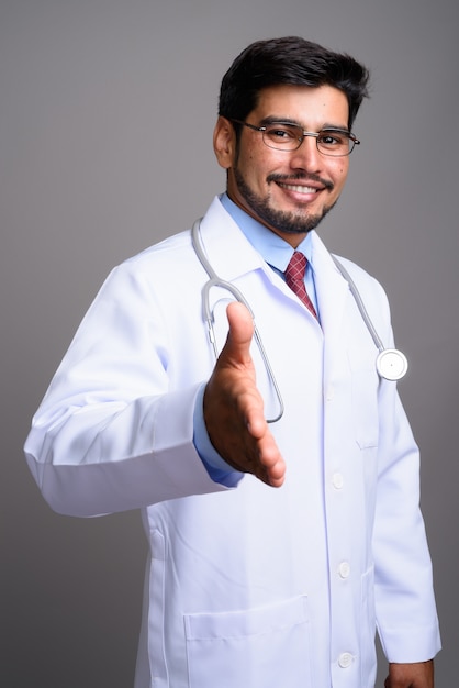 young handsome bearded Persian man doctor wearing eyeglasses 