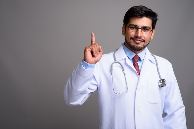 young handsome bearded Persian man doctor wearing eyeglasses 