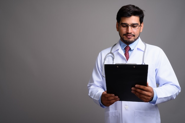 Giovane bello barbuto medico persiano uomo che indossa occhiali da vista