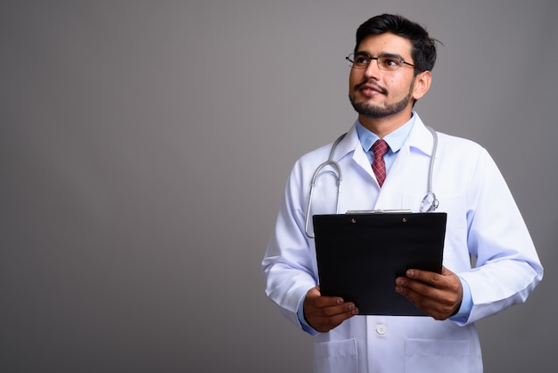 young handsome bearded Persian man doctor wearing eyeglasses 