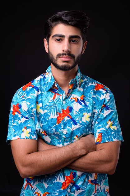 young handsome bearded Persian tourist man ready for vacation on black