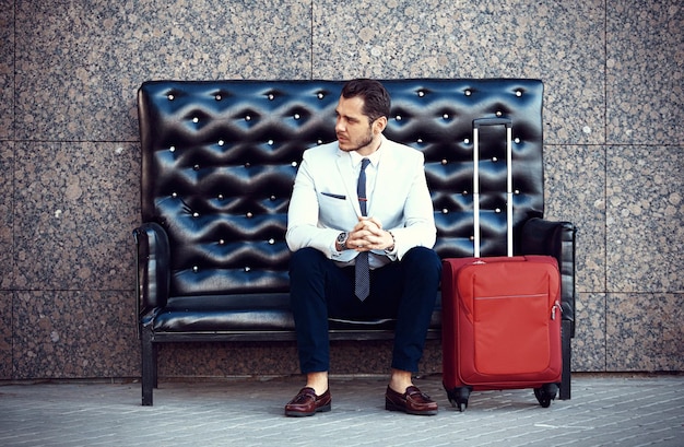 Photo young handsome bearded stylish man sitting on comfortable leather sofa outdoors