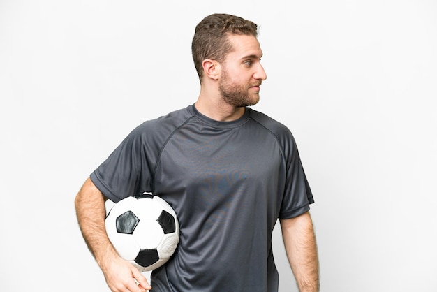 Young handsome blonde man over isolated white background with soccer ball