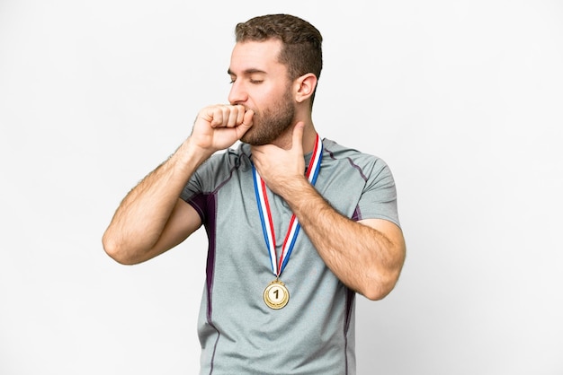 Young handsome blonde man with medals over isolated white background is suffering with cough and feeling bad