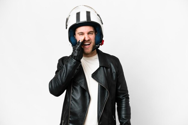 외진 흰색 배경 위에 오토바이 헬멧을 쓴 젊고 잘생긴 금발의 남자가 입을 크게 벌리고 소리치고 있다