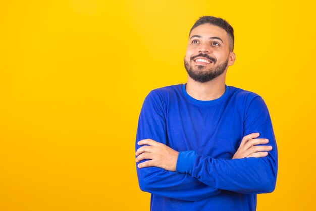 Young handsome boy smiling looking at camera with arms crossed