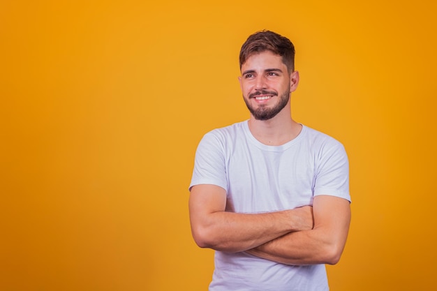 Young handsome boy smiling looking at camera with arms crossed.