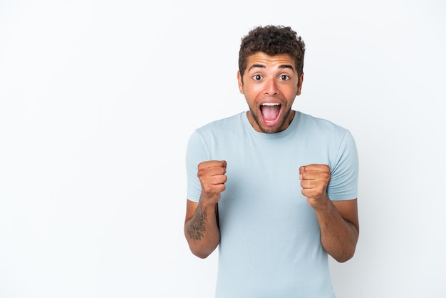 Young handsome Brazilian man isolated on white background celebrating a victory in winner position