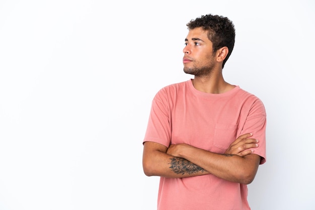 Young handsome Brazilian man isolated on white background looking to the side