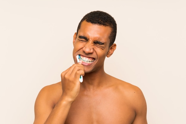 Photo young handsome brunette man brushing his teeth