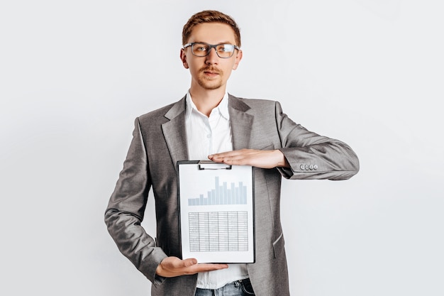 Young handsome brunette man in glasses with document on white isolated space